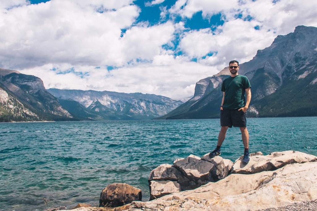 man posing in front of lake minnewanka banff national park